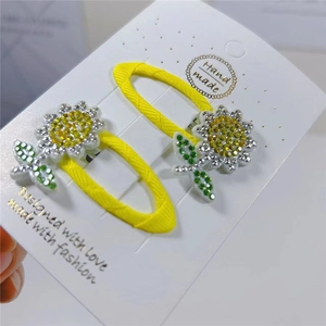 Close-up of handmade sunflower hair clips with sparkling yellow rhinestones for girls