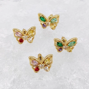 Detail of four colorful zircon butterfly earrings on white crystals with golden bases