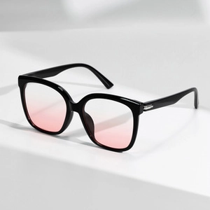 Detail view of round black frame sunglasses with pink gradient lenses from a 45-degree angle