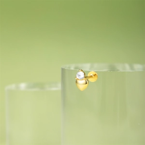 Macro shot of gold heart stud earring with clear sparkling zircon and flat back screw