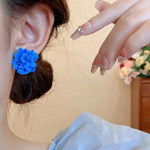 Détail de la boucle d'oreille fleur 3D bleu Klein au fini mat portée par un mannequin