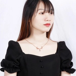 Collier bois de cerf en or rose avec pendentif goutte d'eau porté par un mannequin