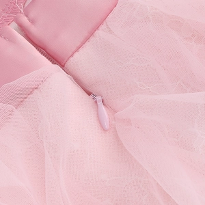 Close-up of invisible zipper detail on pink mesh and lace layered evening dress