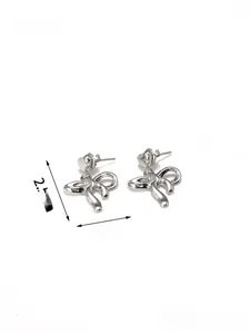 Detail shot of silver bow earrings with heart stud showing dimensions 2.5x2cm and 5.5g weight
