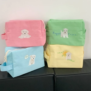 Stack of four canvas makeup bags in pink, green, blue and yellow with cute puppy prints