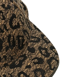 Close-up of vintage bronze woven texture and black leopard print on baseball cap fabric