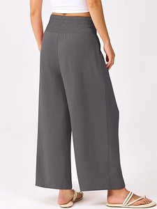 Détail de la taille haute élastique et du tissu plissé sur un pantalon gris large