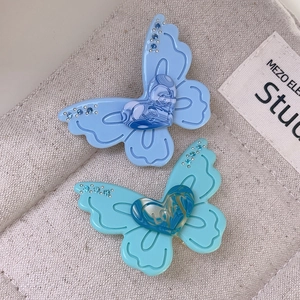 Detail of blue butterfly hair clips with LOVE heart engraving and rhinestone accents