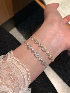 Close-up of adjustable 18K gold and silver plated bracelets with square zircon flowers