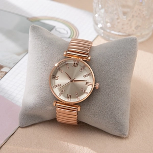 Close-up of rose gold watch with rhinestone dial on a velvet cushion setup