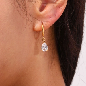 Pendientes de aro en oro de 18K con circonita en forma de gota mostrados en modelo