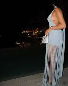 Detailed view of light blue halter dress featuring pleated fabric and long tiered fringe