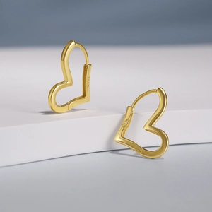 Macro shot of S925 sterling silver stamp on golden heart-shaped hoop earring detail