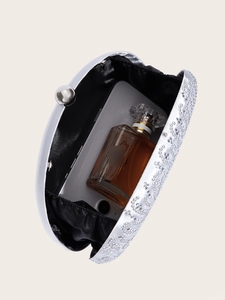 Detailed interior view of silver rhinestone evening bag showing capacity for phone and perfume