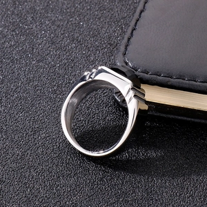Detailed view of men's silver steel ring with octagon cut black gemstone on leather surface