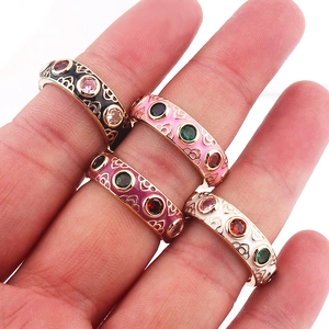 Detail of colorful enamel stackable rings with inlaid cubic zirconia on female hand