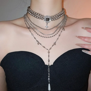 Detail of layered grey pearl choker with black gemstone and silver tassel pendant
