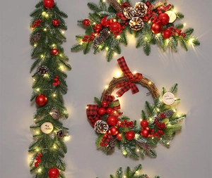 Detail of Christmas wreath with red ornaments, pine cones and warm LED string lights