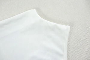 Detailed view of the clean-cut neckline and fine stitching on a white knit garment
