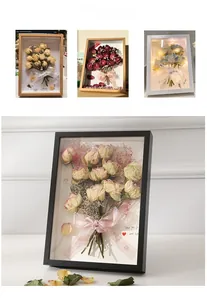 Detail of wooden deep shadow box frame with dried roses and decorative ribbons