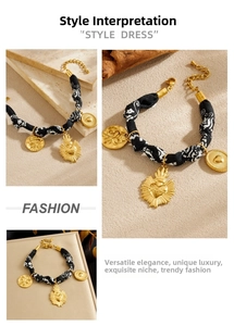 Macro shot of baroque gold-plated charms on black and white floral fabric bracelet