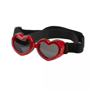 Macro detail of red heart-shaped pet sunglasses with adjustable elastic strap and vents