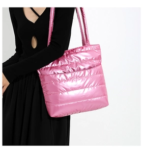 Metallic pink quilted tote bag showing a model's upper body view with a shoulder strap
