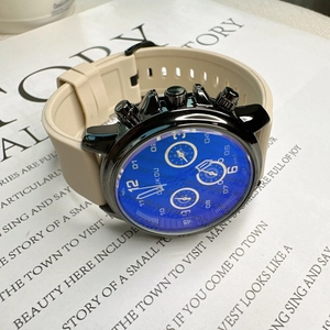 Detail shot of FOUKOU chronograph watch with blue dial and beige silicone strap on paper