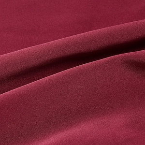 Macro detail of wine red satin fabric showing high-quality texture and silky draping
