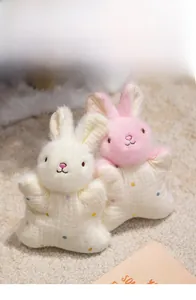 Close-up of rabbit finger puppet with soft plush head and colorful polka dot cotton body