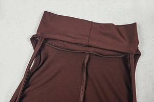 Detail of high neck and neat stitching on chocolate brown sleeveless dress fabric