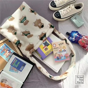 Flat lay of soft faux fur tote bag with brown bear patterns on a cozy grey bedding