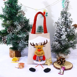 Close-up of burlap Christmas gift bag with a 3D plush reindeer and red checkered handle