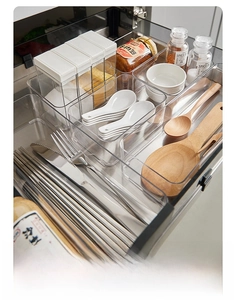 Close-up of clear modular drawer organizers with utensils in a kitchen storage setting