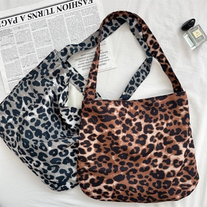 Flat lay of leopard print canvas tote bags in brown and grey with minimalist aesthetic