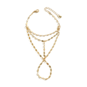 Detailed macro view of gold layered beach hand chain with faux pearls and rhinestones