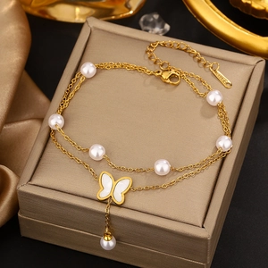 Detail of a gold double-layer butterfly bracelet with pearls on a luxury jewelry box