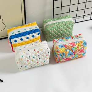 Variety of quilted cotton makeup bags with colorful floral and polka dot patterns for travel