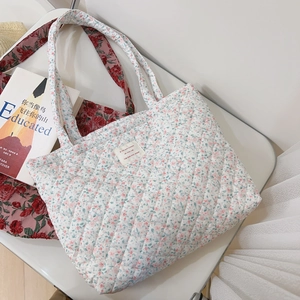 Détail du sac cabas matelassé en coton à fleurs montrant la texture et l'étiquette