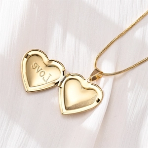 Golden heart locket necklace with fine snake chain and inner Love engraving detail