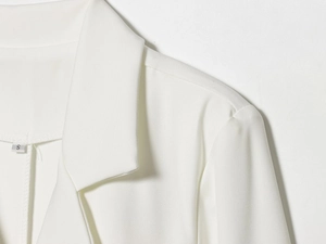 Detail of elegant white blazer neckline and shoulder with woven fabric texture