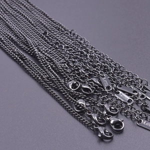 Close-up of 2.2mm black stainless steel flat chains with lobster clasps and S.STEEL tags