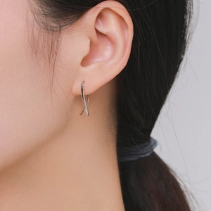 Elegant S925 sterling silver geometric crisscross earrings worn on a female model