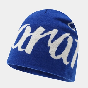 Detailed close-up of dark blue beanie showing white script lettering and knit texture