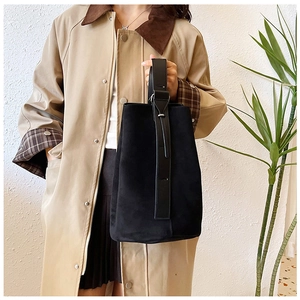 Detail of minimalist black faux suede tote bag with leather straps and metal buckle
