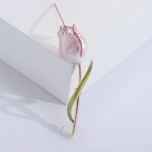 Close-up of pink tulip brooch with green enamel leaves and polished gold stem