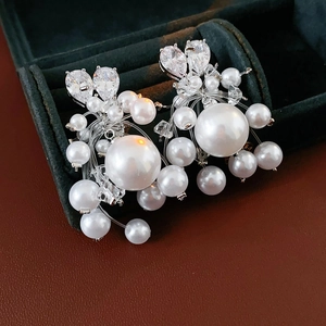 Macro detail of luxury cluster pearl earrings with zircon stones on green velvet box