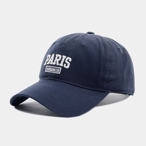 Detailed side view of navy baseball cap with white embroidered Paris French lettering