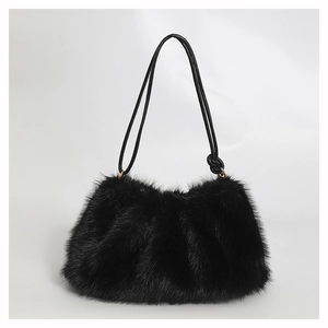 Vue détaillée du sac à main en fausse fourrure noire avec lanières en cuir et doré métal