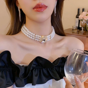 Gros plan du collier de perles vintage et des boucles d'oreilles à franges sur modèle